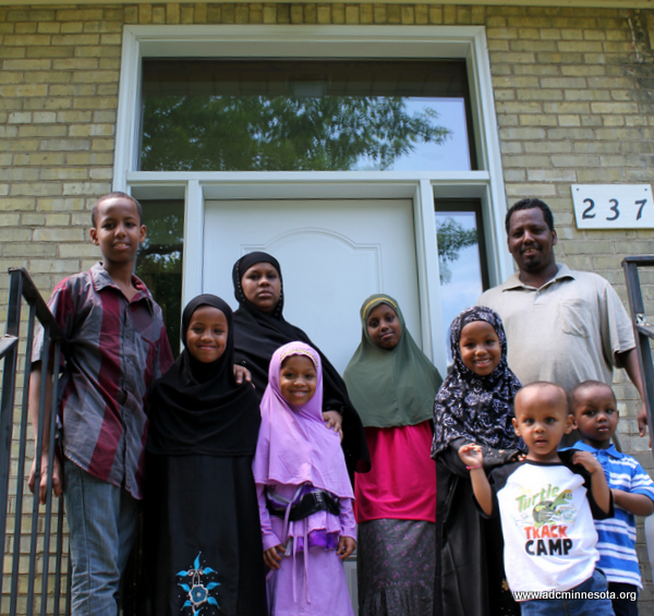 a somali family of nine outside their new home