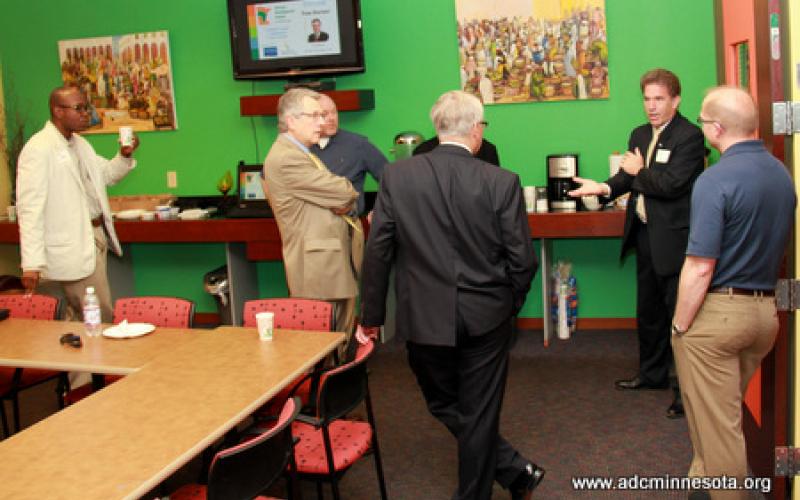 Tom Horner and gathered participants chat informally