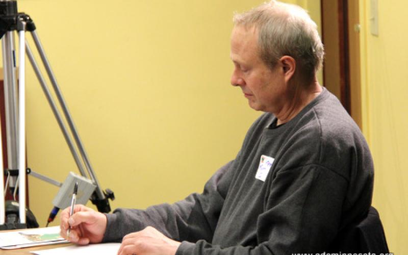 A participant takes notes during the presentation