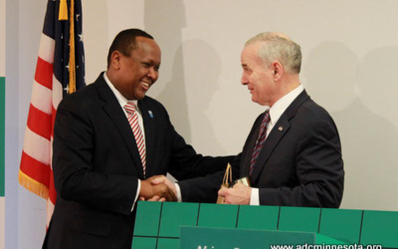 Hussein Samatar shakes Governor Mark Dayton's hand at the podium