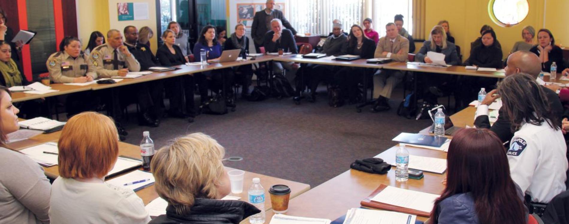 Participants at an ADC seated around a square of tables